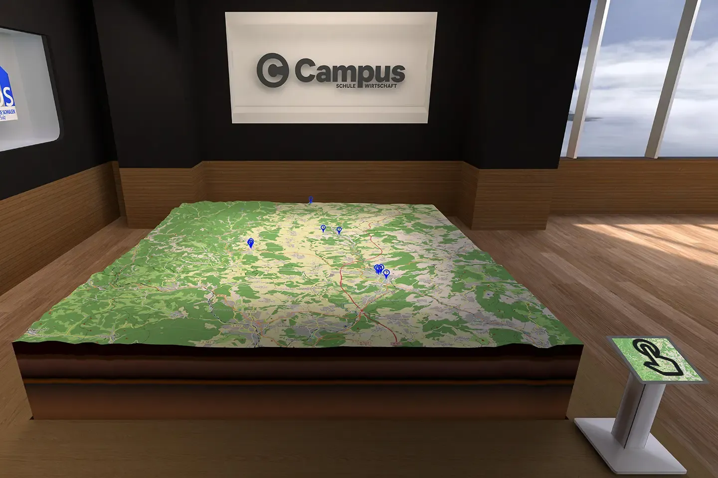 Virtual relief model of the region with blue location markers in front of a wall with the Campus logo