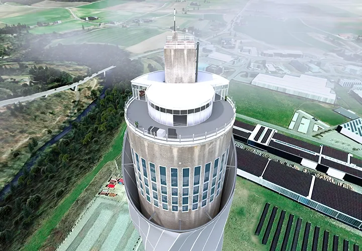 Bird’s-eye view of the virtual test tower with an observation deck, fields and industrial buildings below
