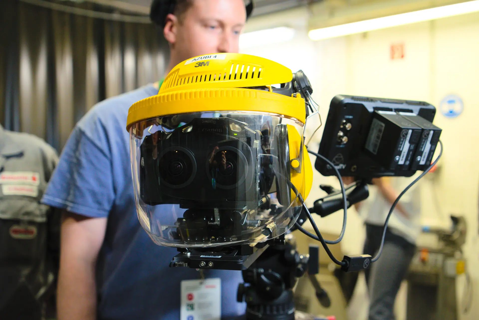 3D camera behind a yellow face shield visor that protects it from flying sparks during the shoot