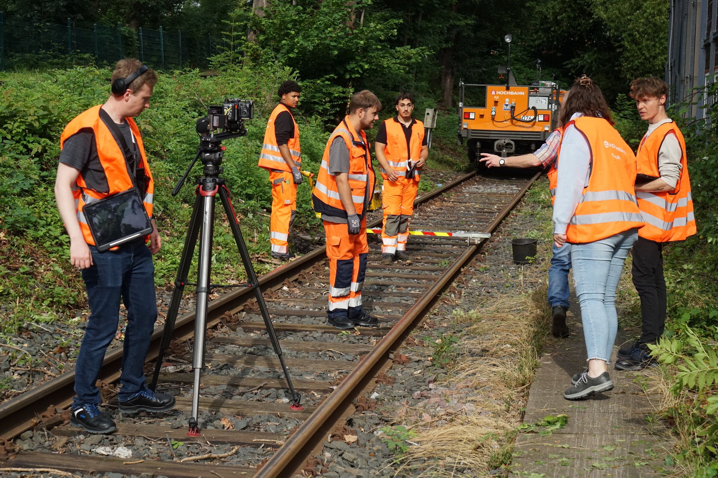 Shoot at Hamburger Hochbahn: the crew in safety vests sets up the camera on a track, with a shunting locomotive in the background
