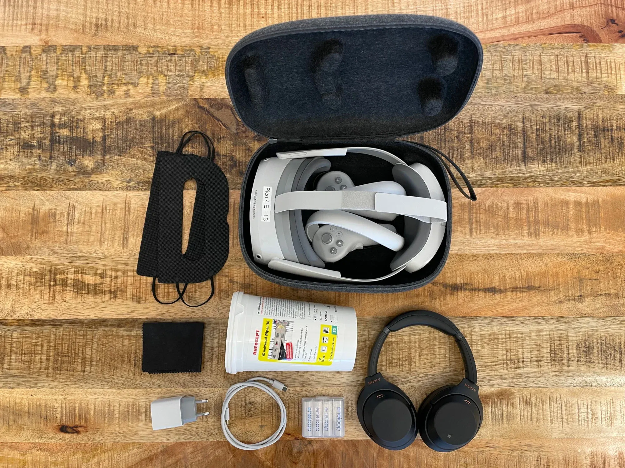 Pico 4 Enterprise with a sticker reading Pico 4 E – L3 in its case, next to a hygiene mask, cleaning cloth, disinfectant wipes, charger, batteries and headphones