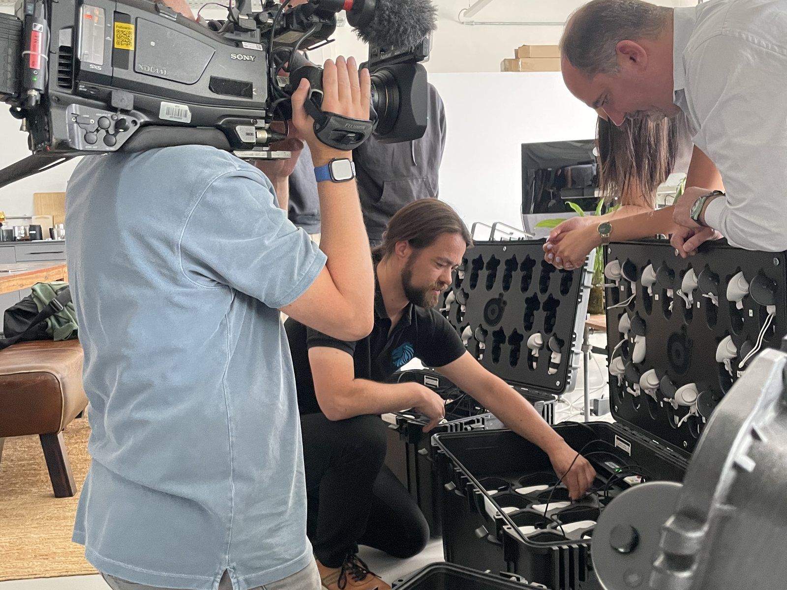 A TV crew films VR headsets being taken out of transport cases