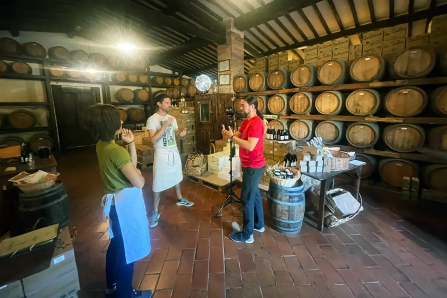 Planning the shot among wine barrels: two Fattoria staff members and a member of the film crew next to the 360° camera