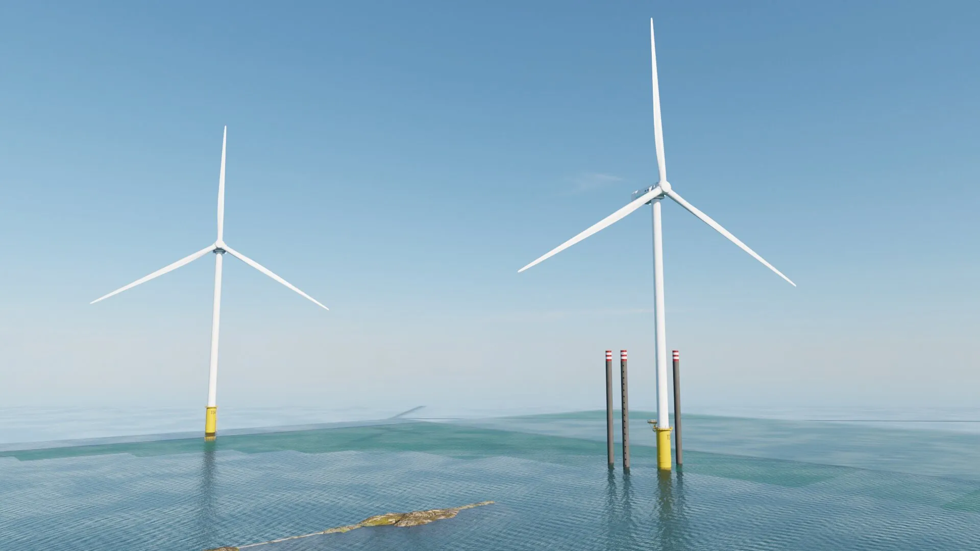 Zwei Windräder auf dem Meer, daneben ragen Fundamentpfähle für weitere Anlagen aus dem Wasser