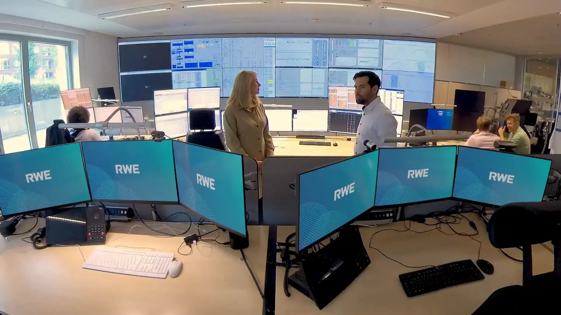 Scene from the 360° video for RWE: two employees at their workstation on the trading floor in Essen, in front of screens with the RWE logo