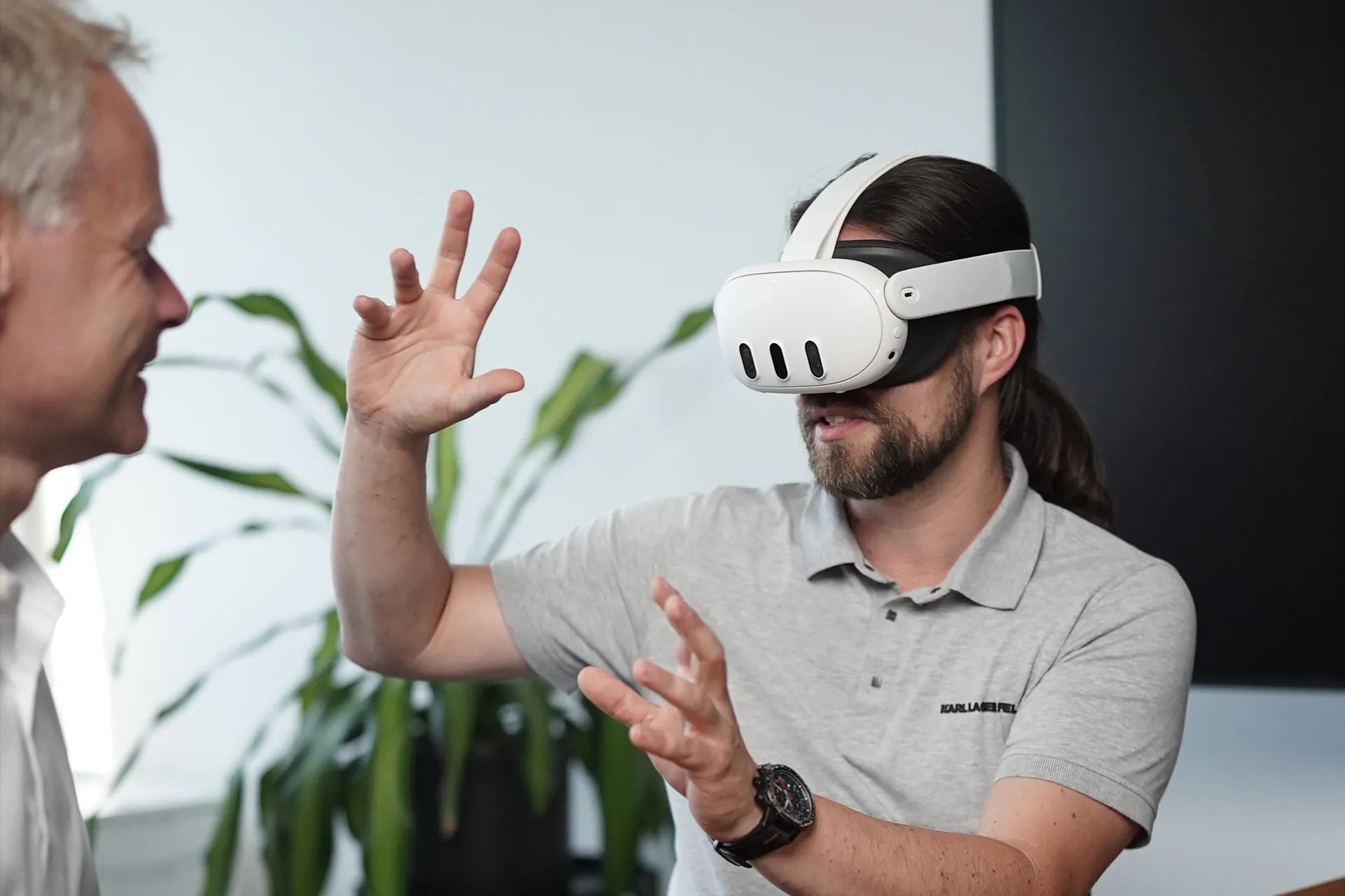 Tim B. Frank wears a Meta Quest 3 and controls the application with bare hands, no controllers, while the person opposite laughs and watches