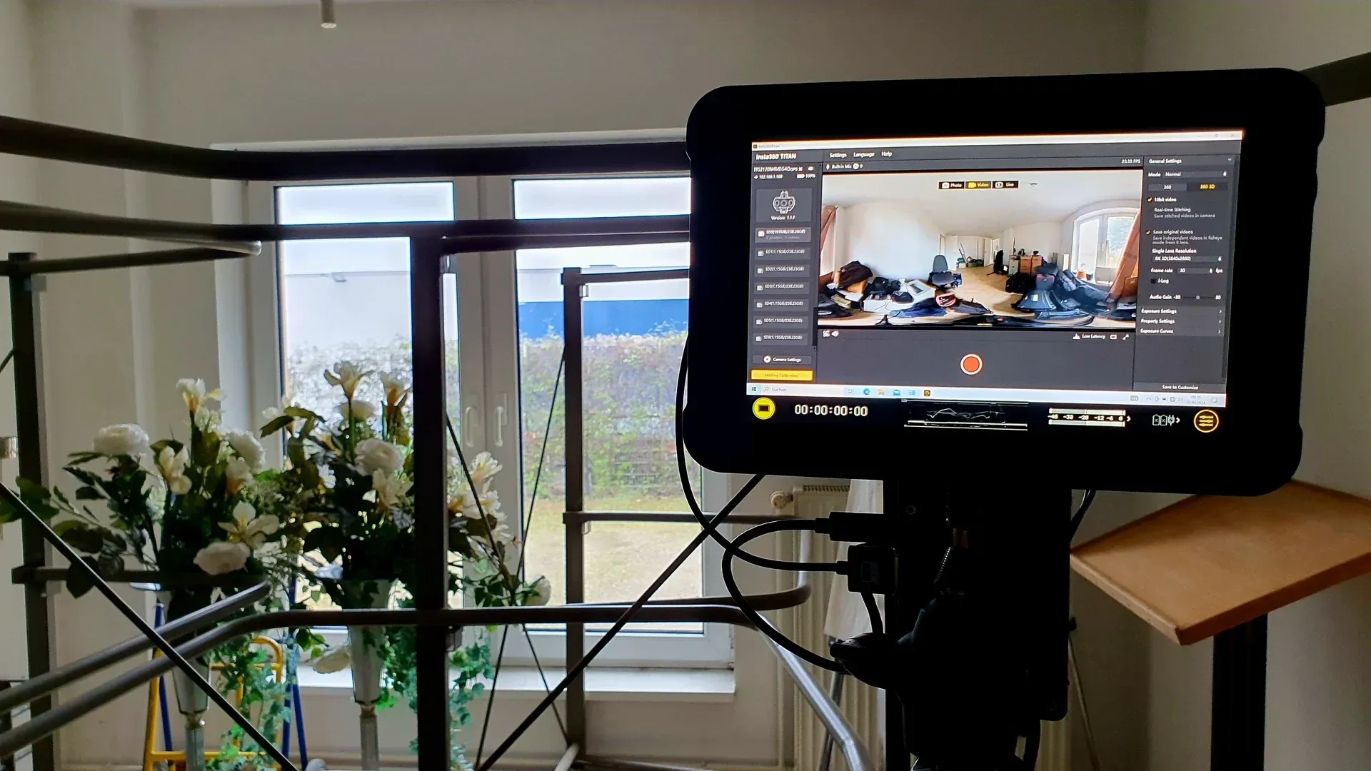 Vorschaumonitor mit der Aufnahmesoftware der Insta360 Titan und einem 360°-Panorama des Drehorts, daneben Blumenschmuck