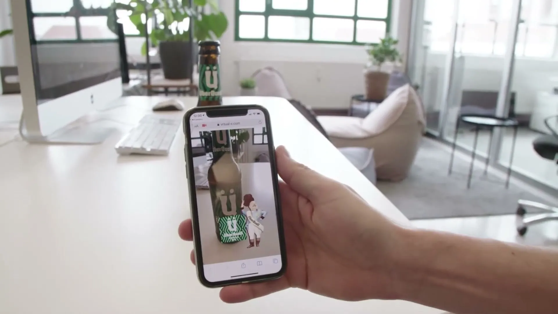 Auf dem Smartphone-Bildschirm steht die gezeichnete Figur Zirkusdirektor Johnny mit Zylinder und Schärpe neben der Bierflasche